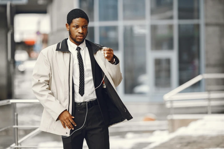 man wearing suit and tie holding up a piece of clothing