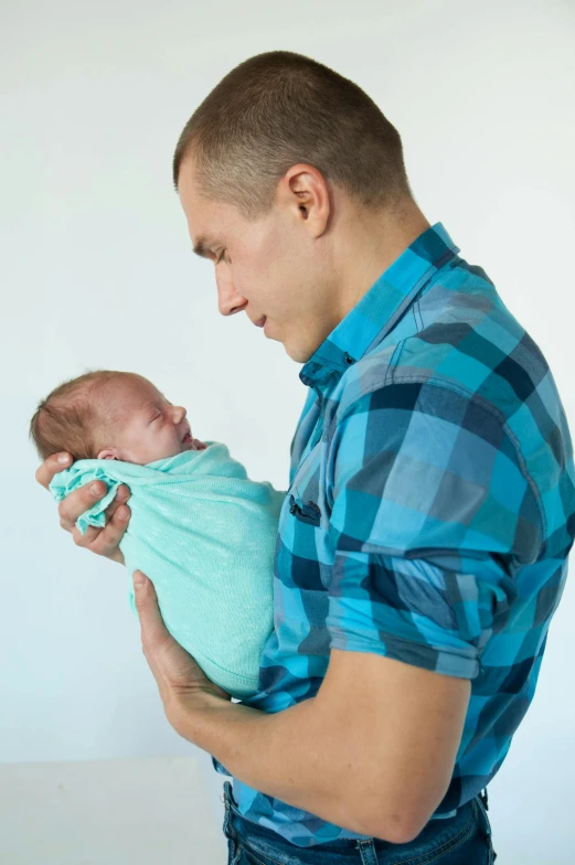 a man is holding his baby while he looks down