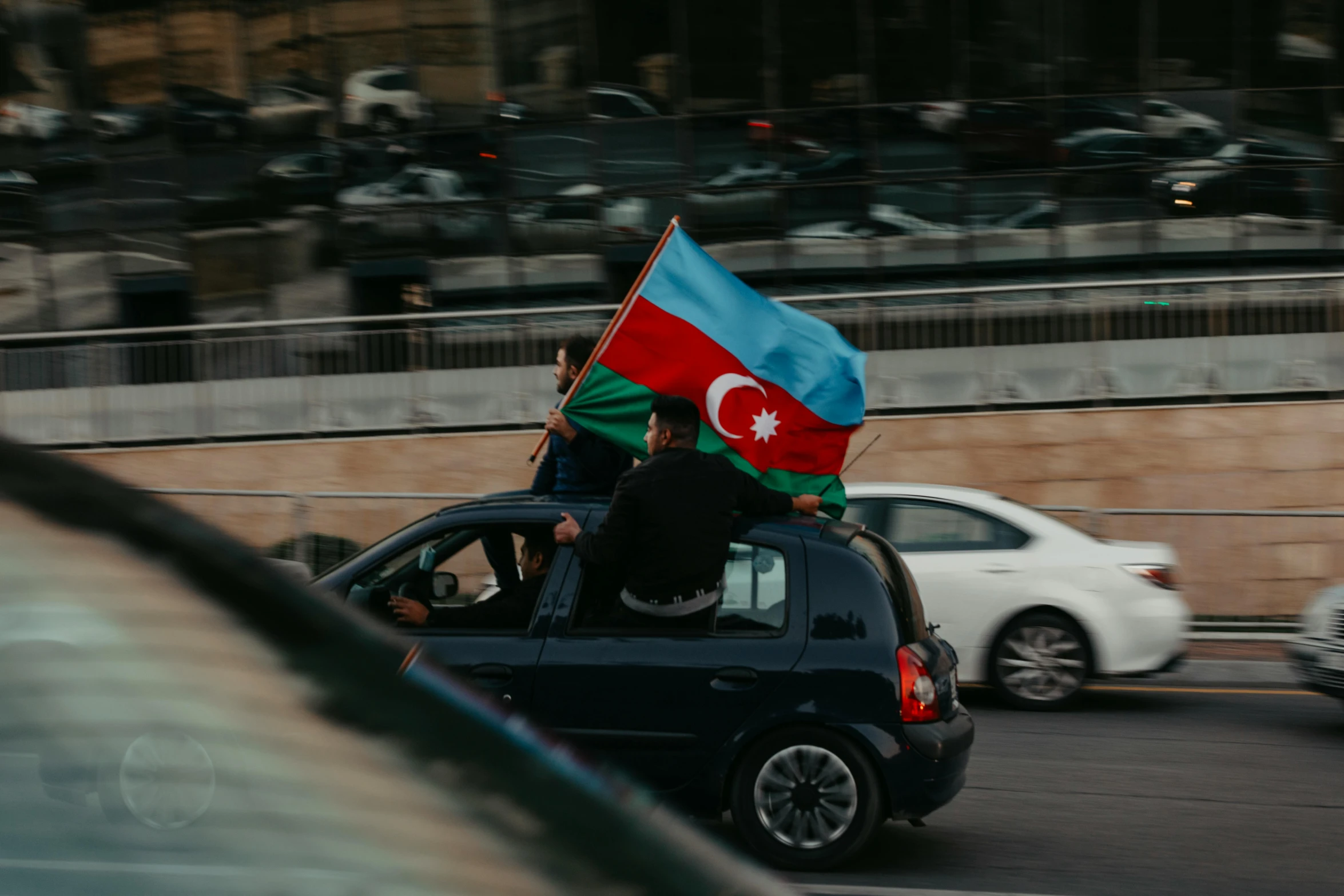 an individual in a car with two flags that are not used