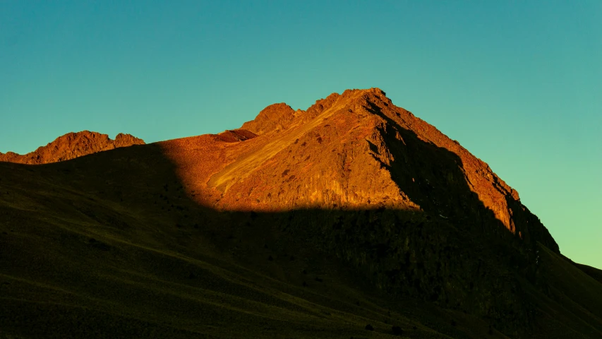 a dark rock ridge on the side of a mountain