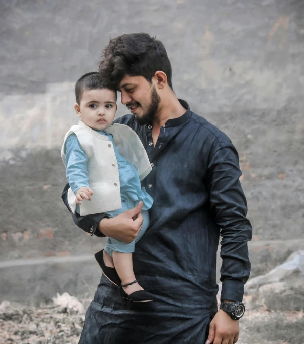 a man holding a child while walking through the desert