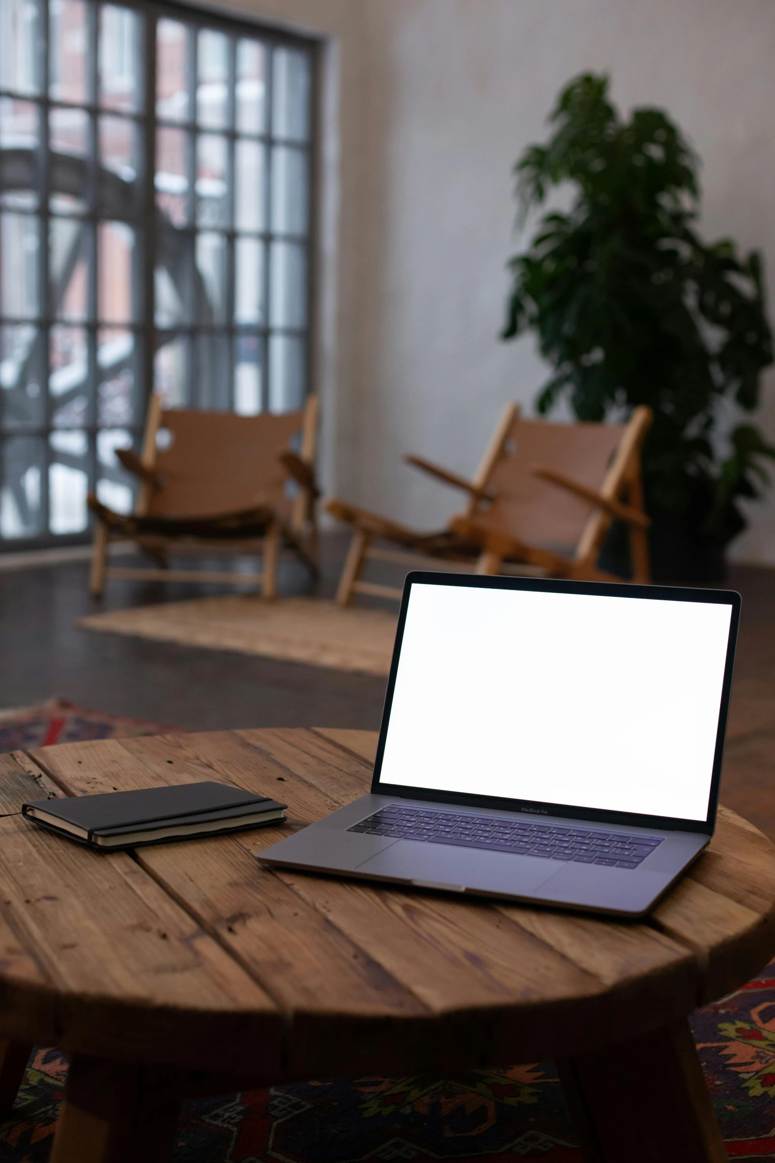 a laptop on a table with a small book