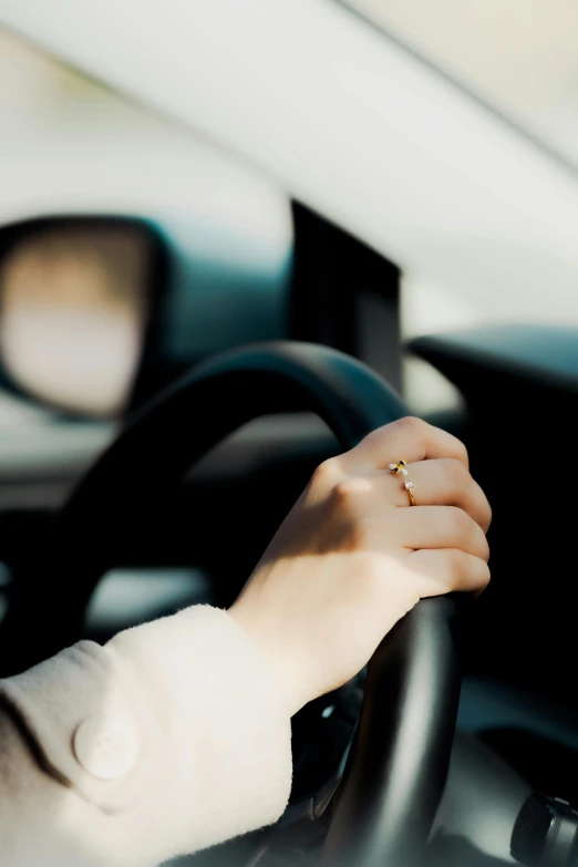 a woman driving the car while holding her hand out