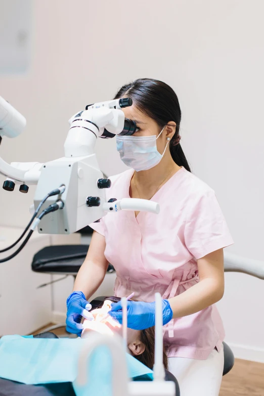 a dentist with a face mask on while holding a 