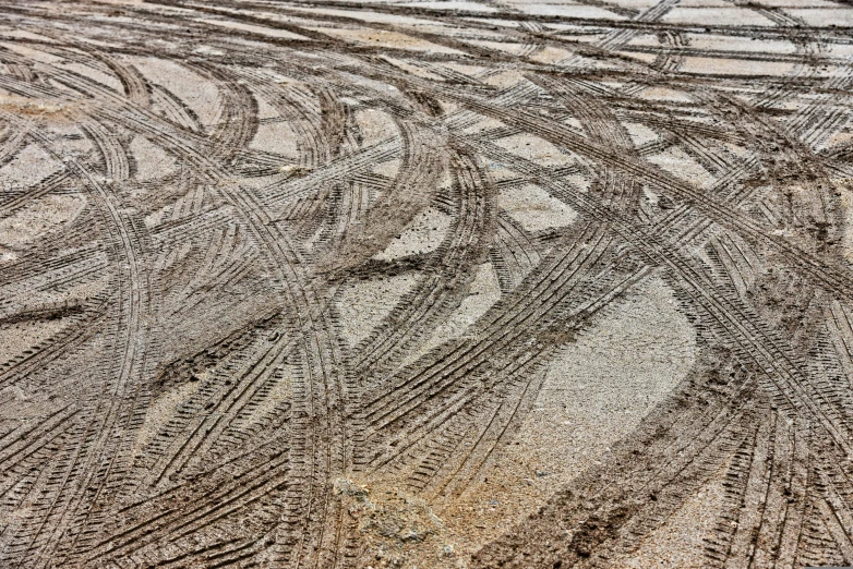 the tire tracks on the side of a dirt road