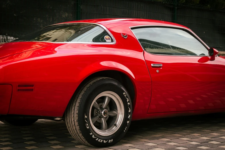 a red chevrolet corvette sits parked on a paved surface