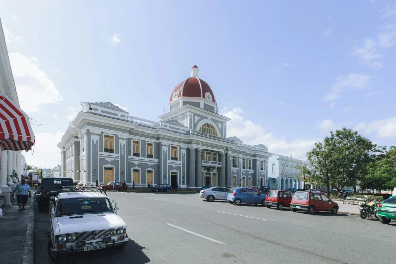 cars are lined up near an old white building