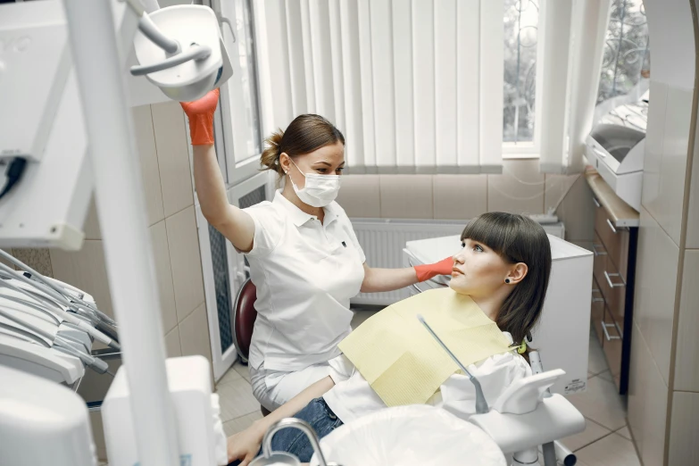 a woman putting an inhalet on her face and the girl in a dentists chair