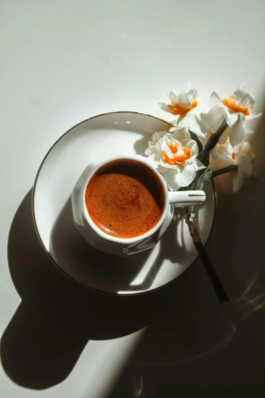 a bowl of chili in the shadow with flowers in it