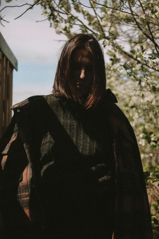 a woman wearing a cloak looking out into the distance