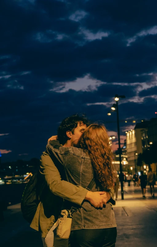 a couple kissing each other on a street