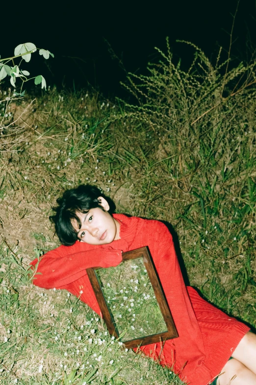 a woman sitting on the ground next to a mirror