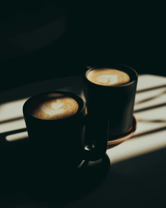 two cups of coffee sit on a saucer