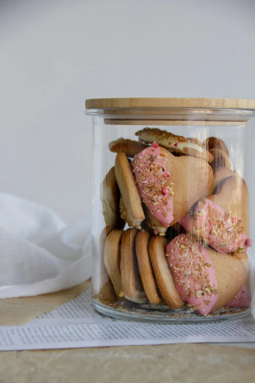 a glass jar that has a bunch of cookies in it