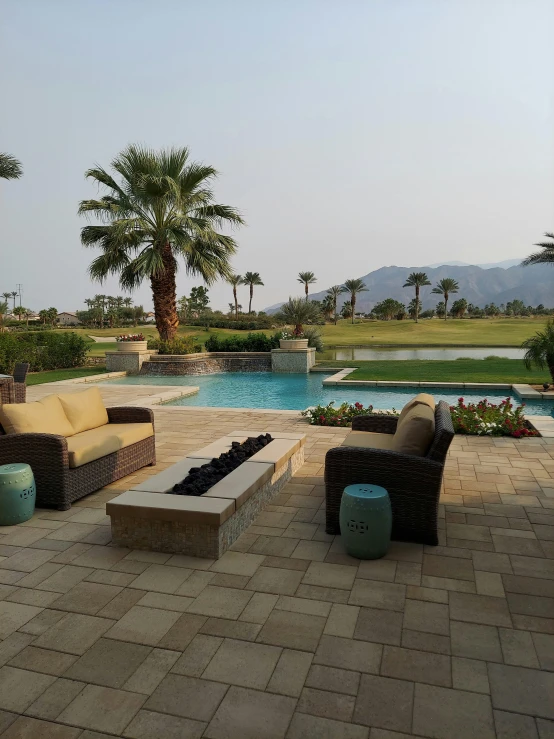 outdoor patio furniture by a pool with palm trees