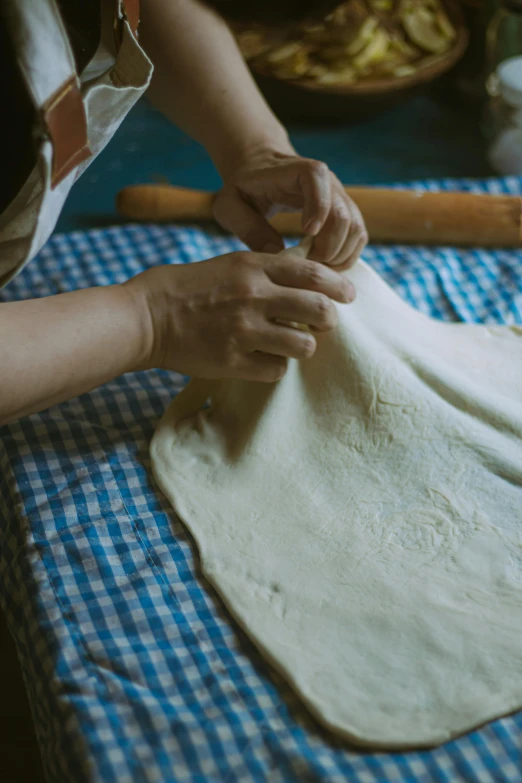 a woman working on pie dough with a rolling pin in the background