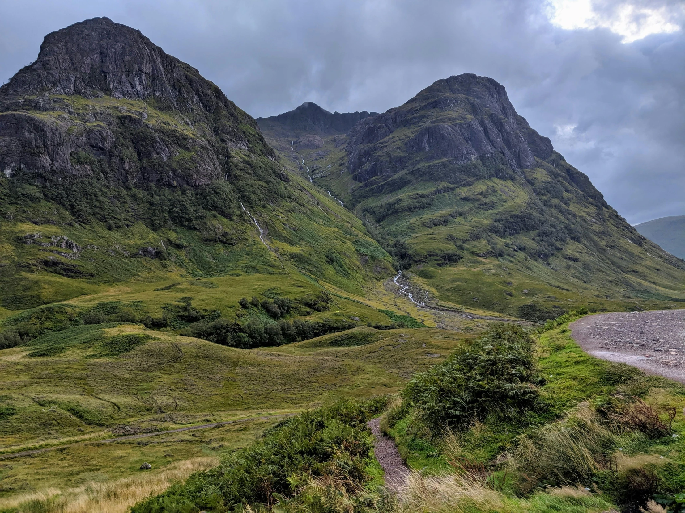 the hills have lush green plants and dirt paths