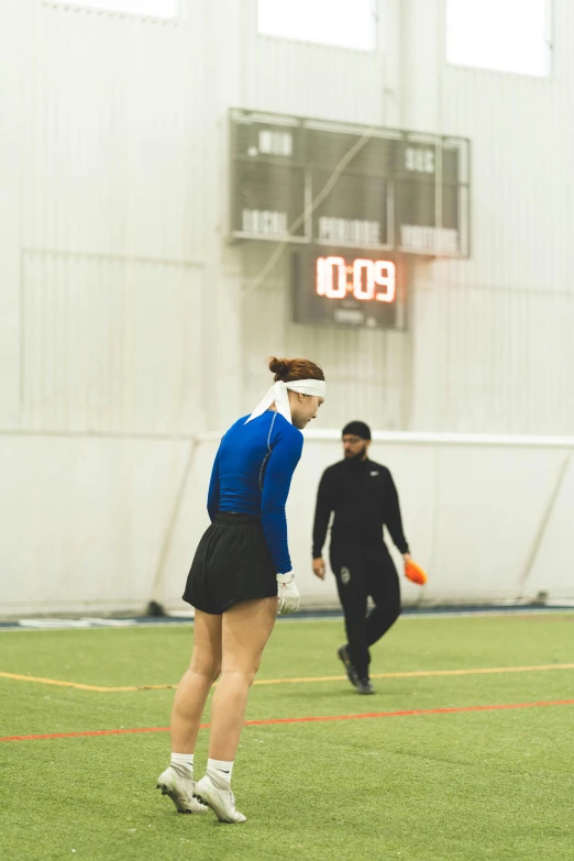 a woman is playing frisbee on the field