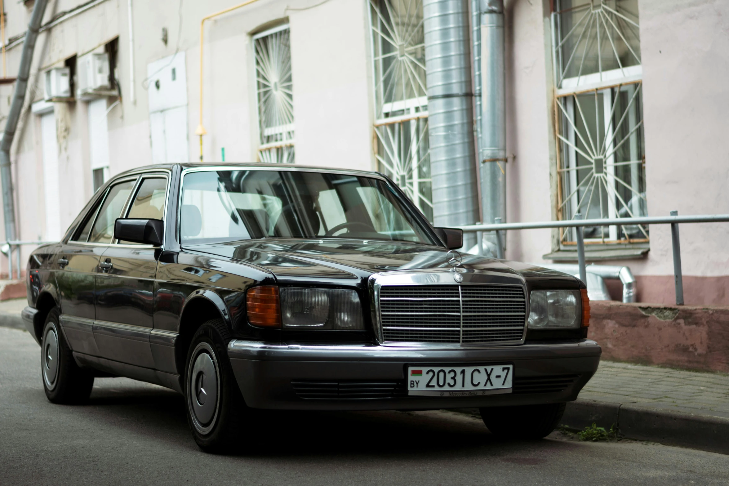 the mercedes is parked along the side of a street