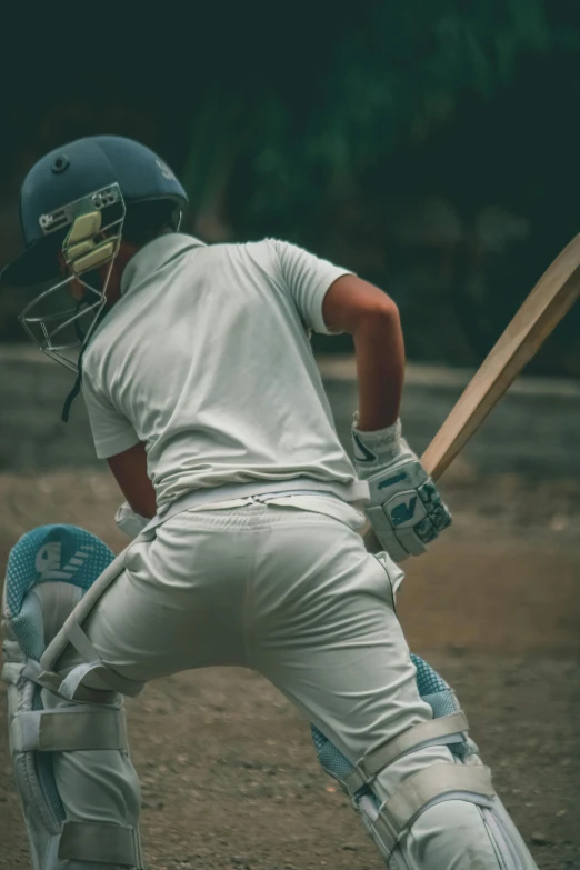 the boy is wearing a helmet and holding a bat