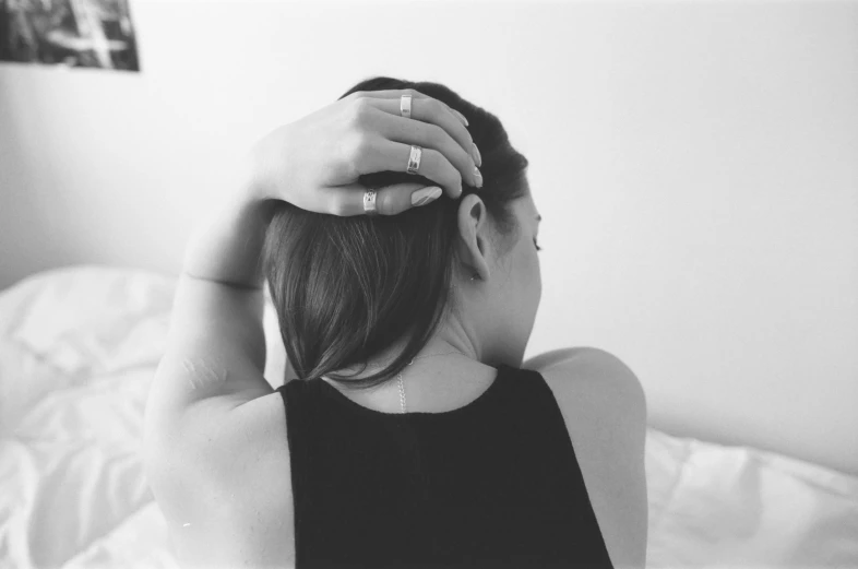 a young woman putting her hand in to her hair