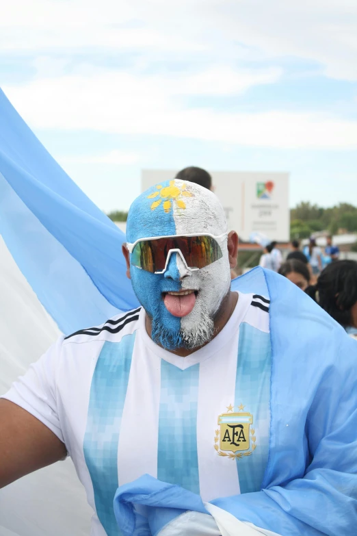 a man with an excited look wearing a soccer shirt