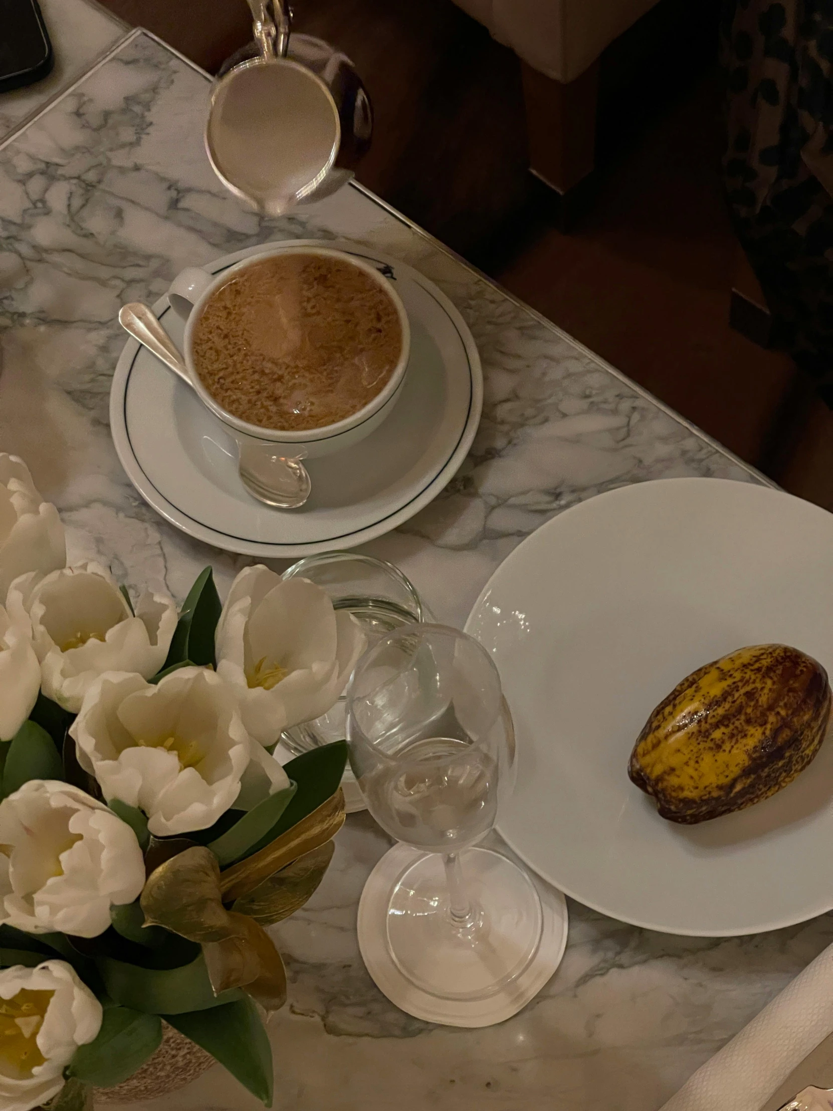 a table with flowers, glasses and food on it