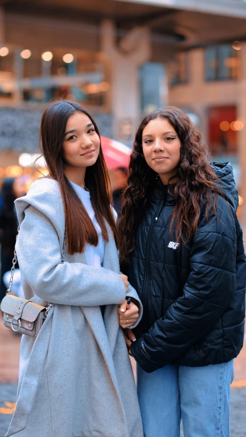 two young women posing for a picture in the city