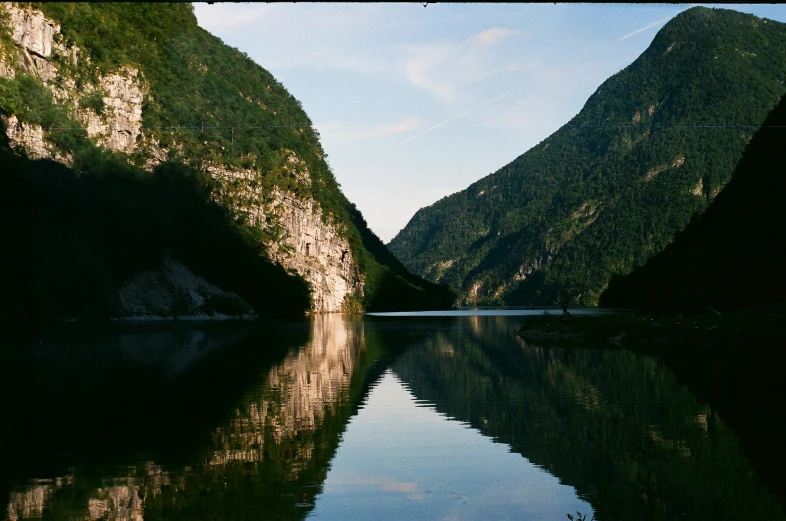 an empty river in the mountains that is covered with lush vegetation