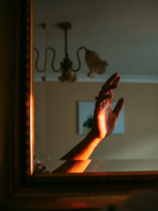 a hand is in front of a mirror