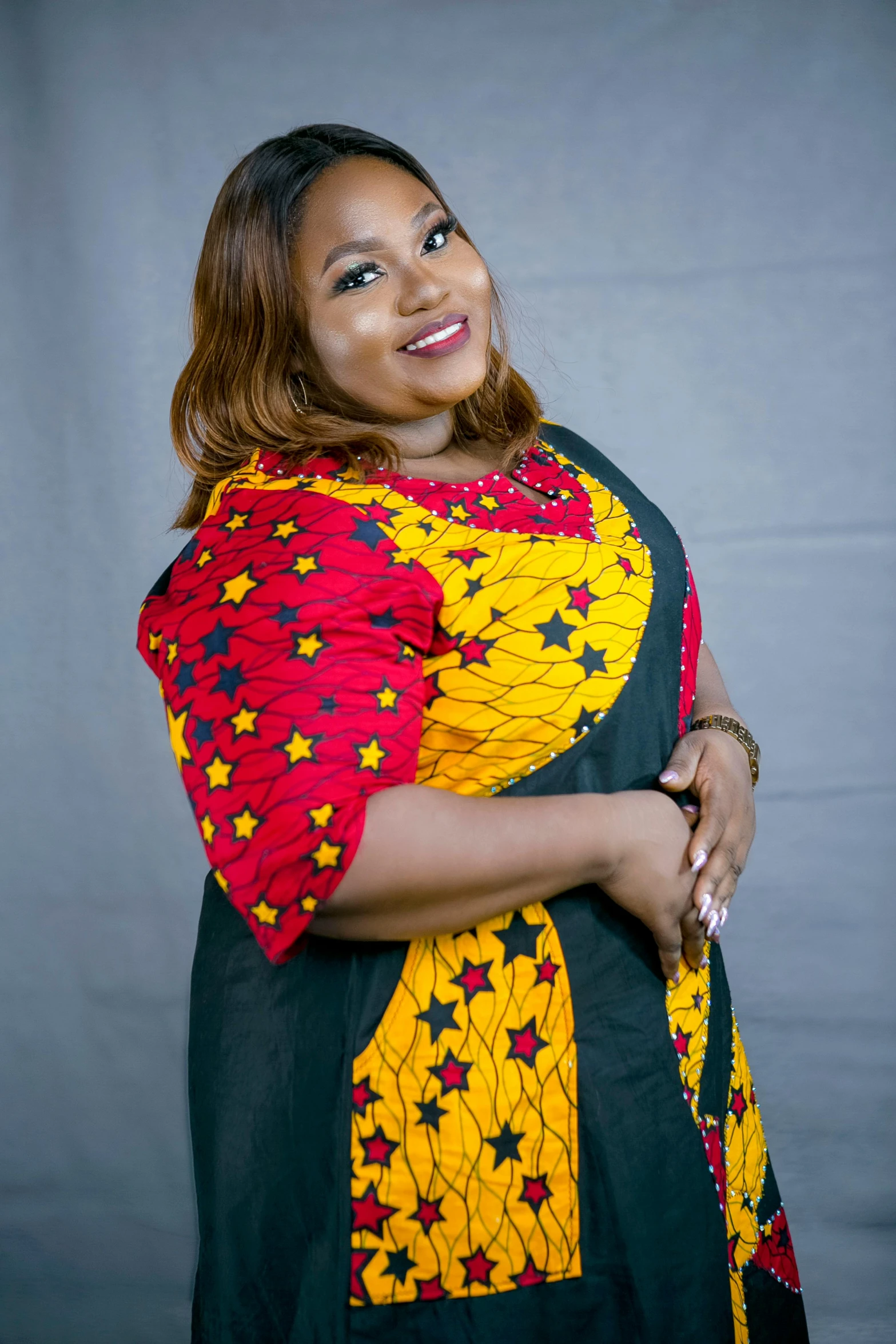 a woman smiles while wearing an african dress