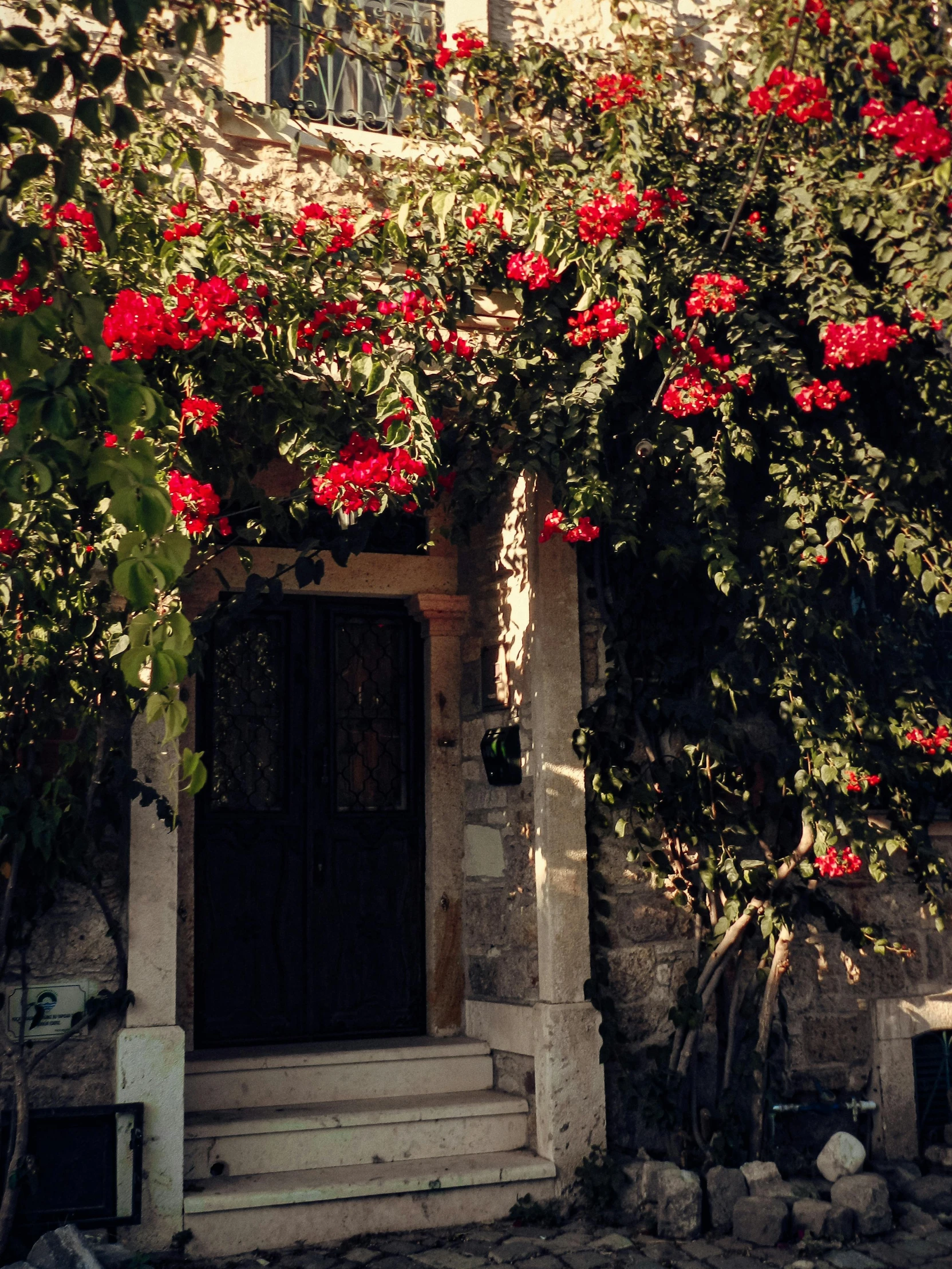 a stone building with flowers on the side