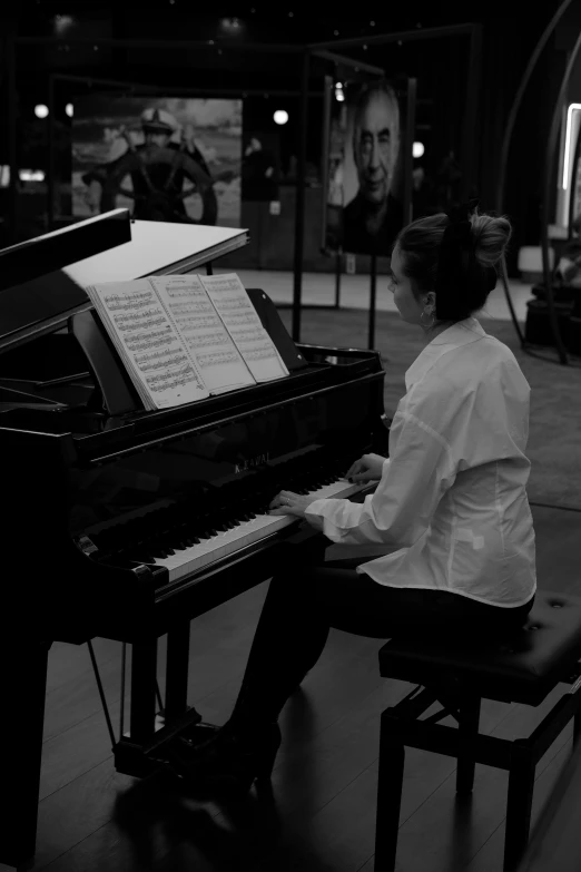 a woman is playing the piano in front of people