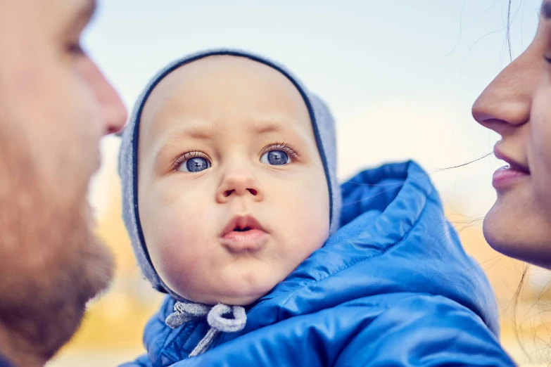 a baby looking into the distance with a person in front