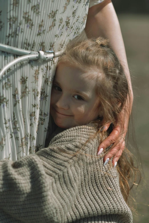 a  smiling in a dress and holding her arms around the back of an older woman's arm