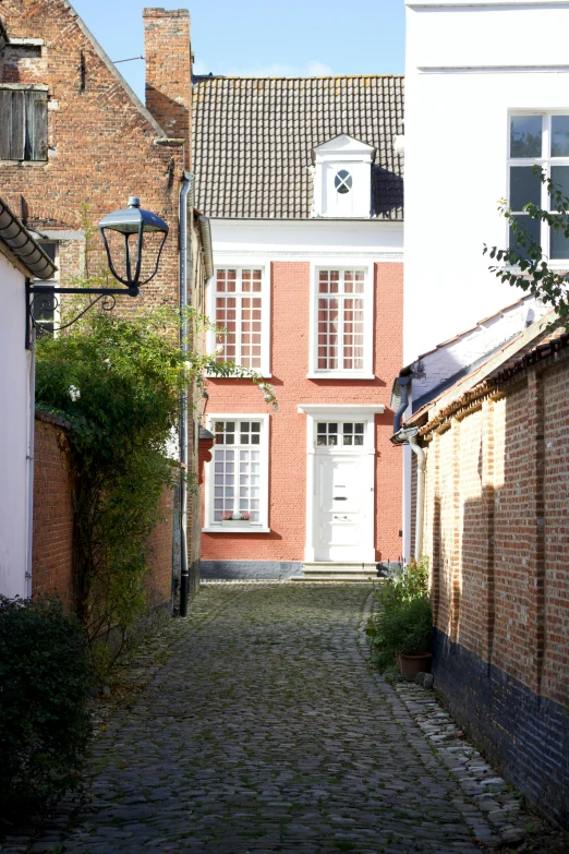 an old alley way with a clock on a building on the side