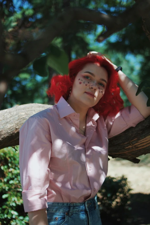 red hair girl in jeans leaning against a tree nch