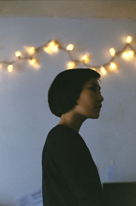 a woman standing under lights on a wire