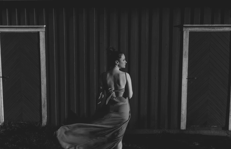 black and white po of a woman standing outside a building