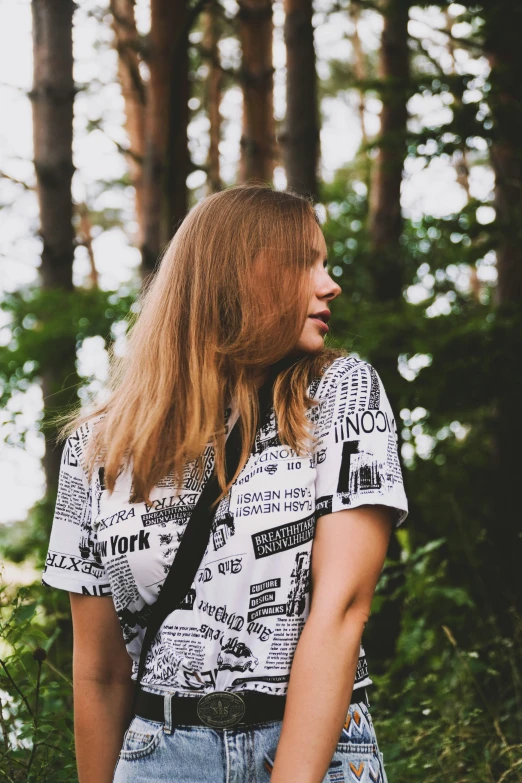 a beautiful young lady standing in the woods with long hair