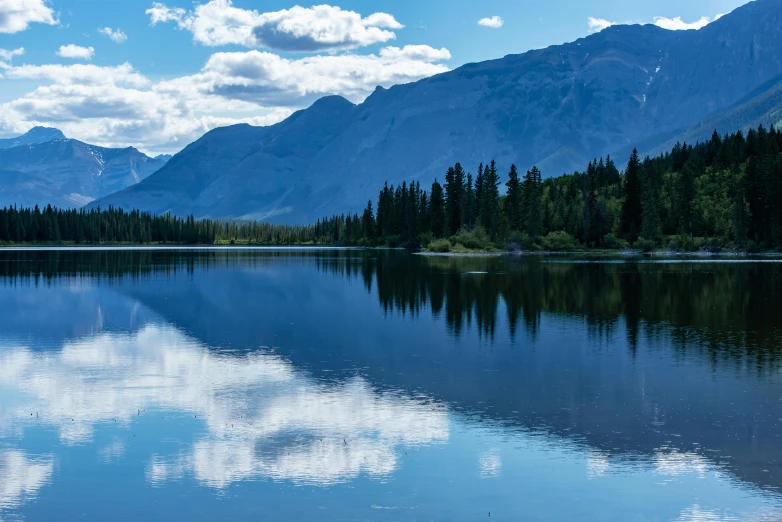 a lake with mountains and trees in the background