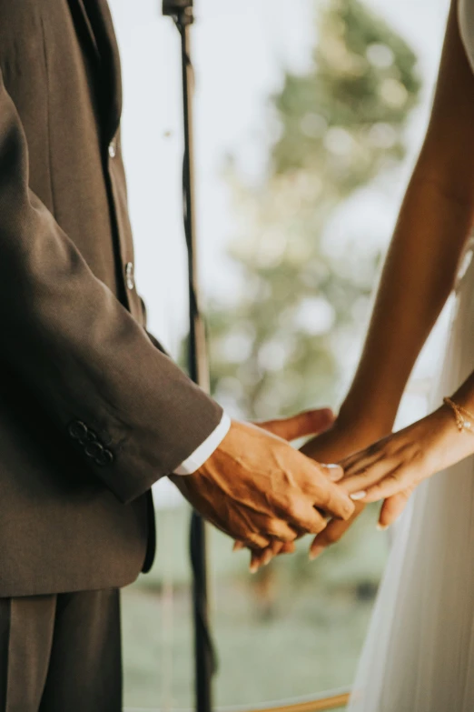 a bride and groom hold hands under a wedding microphone