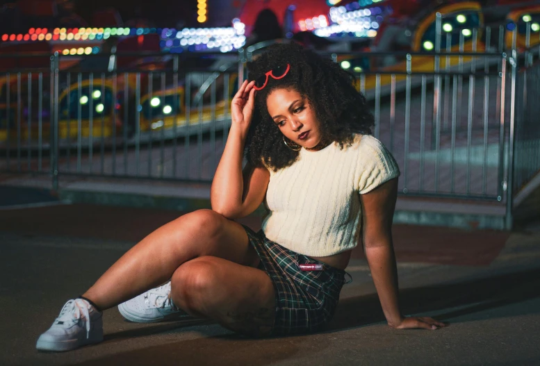 a woman posing for the camera next to a fence