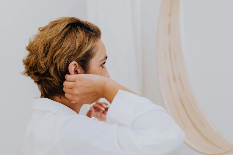 a woman is brushing her hair in front of a mirror