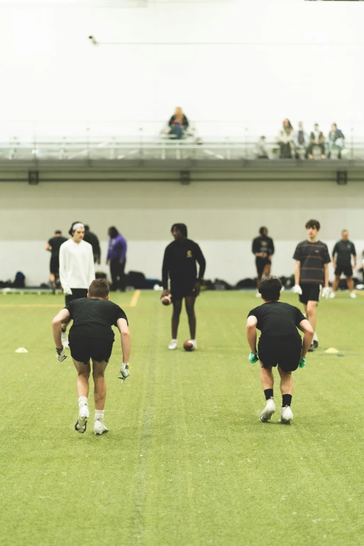 a group of people in shorts and black shirts on some grass