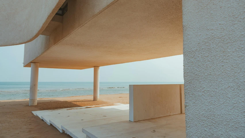 a building with a long white wall next to the ocean