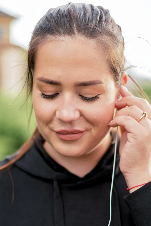 a woman wearing ear buds with an unshaven hairline around her neck