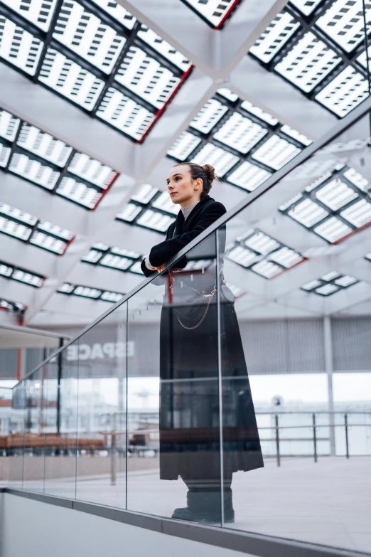 woman standing in building next to glass balconies