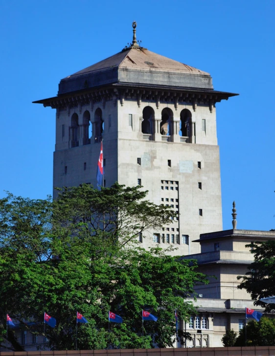 a very large stone tower with flags around it