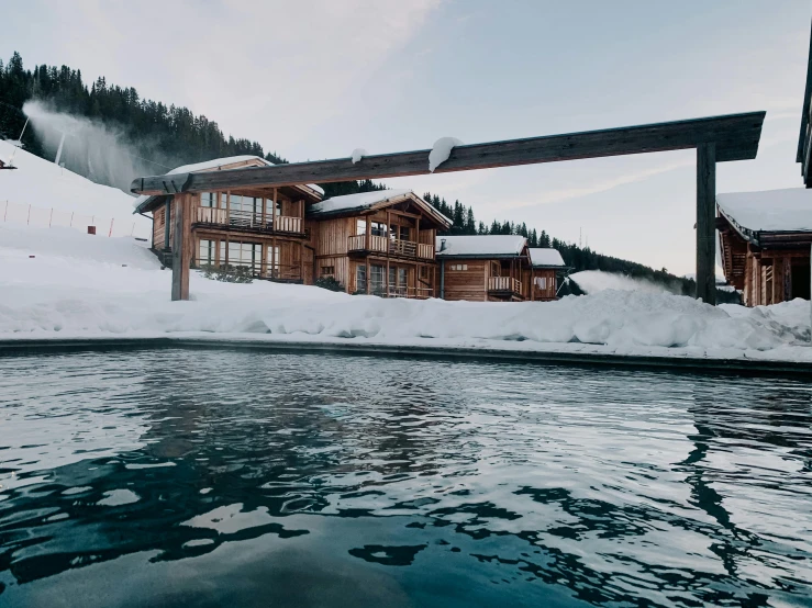 a boat floating past a building in the middle of a snow covered field